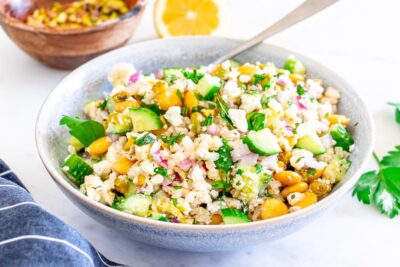 A bowl of lettuce-less salad inspired by actress Jennifer Aniston. Salad is filled with cucumber, cauliflower rice, lupin beans, feta and mint.