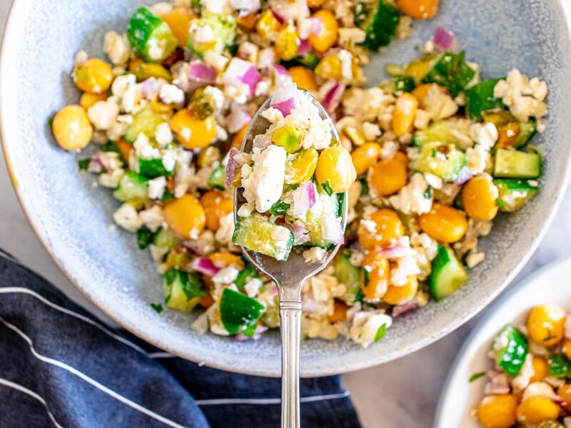 Spoonful of cauliflower rice salad with lupin beans, feta, cucumber, onion and pistachios.