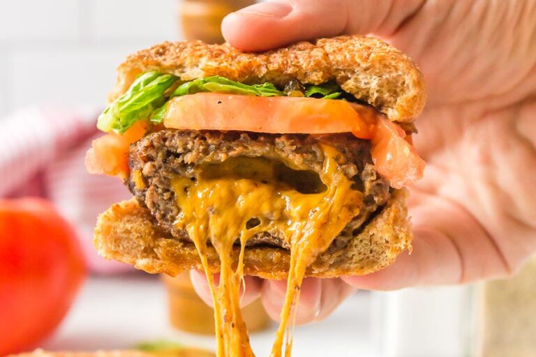 Melted cheese dripping down from a burger.