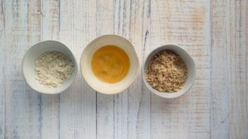 three bowls with almond flour, egg wash and ground pork rinds