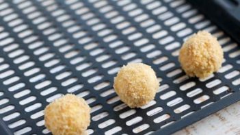 coated cheese balls on an air fryer tray