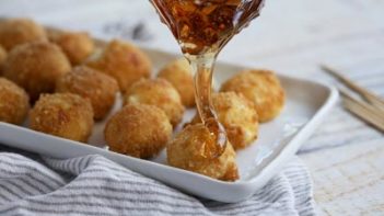 caramel syrup drizzling down onto a goat cheese ball