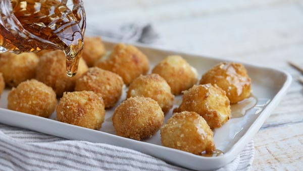 pouring caramel syrup on crispy cheese balls