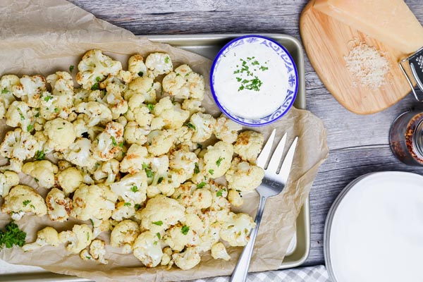 roasted cauliflower laying on a parchment lined baking tray