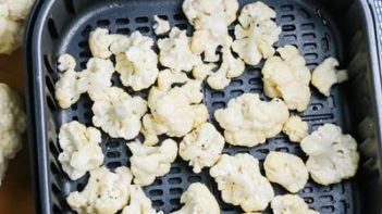 cauliflower florets in an air fryer basket