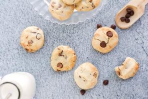 keto chocolate chip cookies on a blue counter with chips around