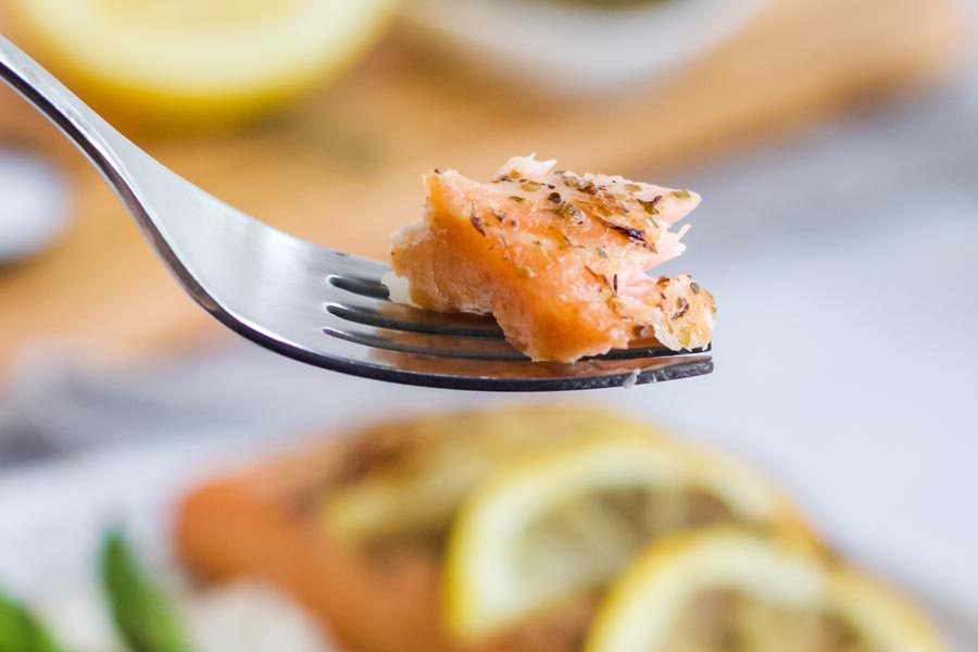 a fork holding a bite of flaky salmon