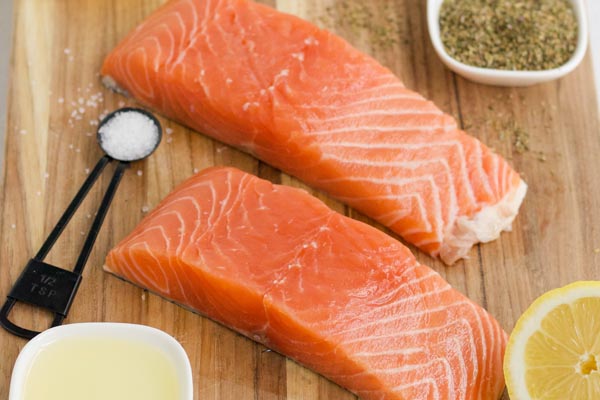 two salmon fillets on a wooden board