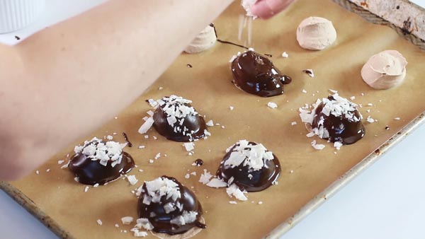 sprinkling coconut flakes onto keto truffles