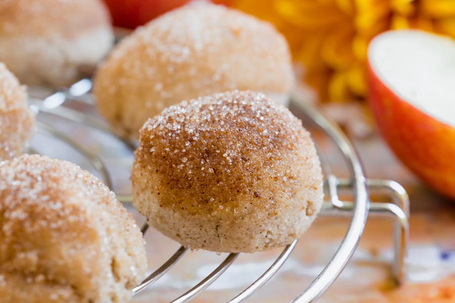 Close-up of a single keto donut bite on a cooling rack, showcasing its golden brown, cinnamon-sugar coated top.
