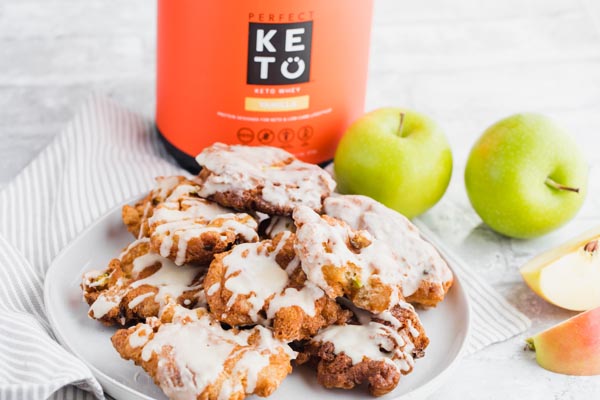 a plate of apple fritters with a canister of protein