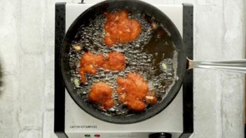 apple fritters frying in a skillet