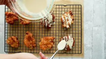 drizzling on glaze on top of an apple fritter