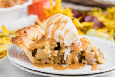 a slice of keto apple pie with vanilla ice cream dripping down and caramel sauce