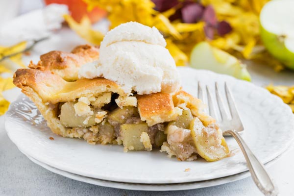 a slice of apple pie made out of squash and topped with vanilla ice cream by a fork