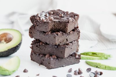 brownies stacked up with an avocado behind them