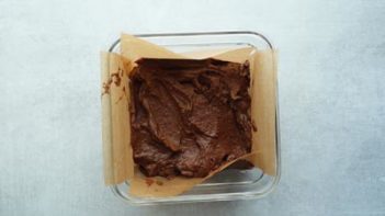 brownie batter in a parchment lined dish