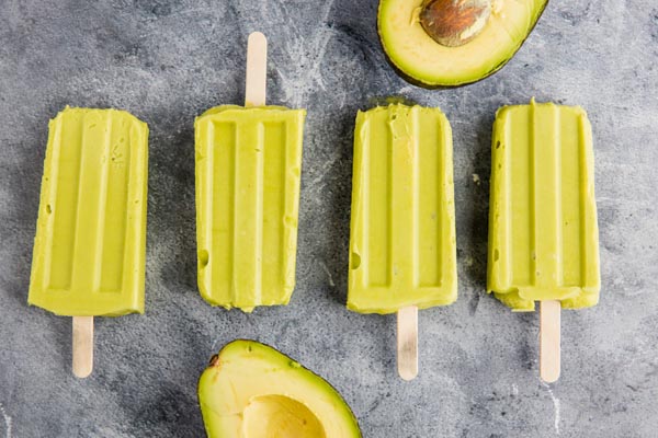 four bright green avocado popsicles in a row