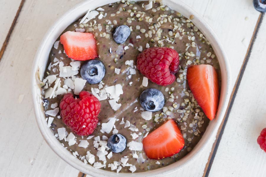 creamy berry filled bowl with coconut and hemp seeds