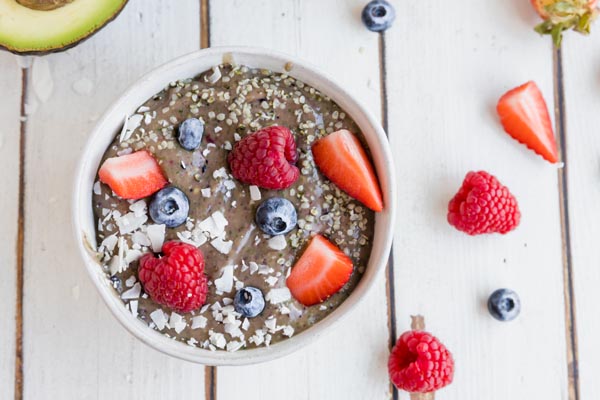 a thick berry bowl with seeds and berries on top and scattered around