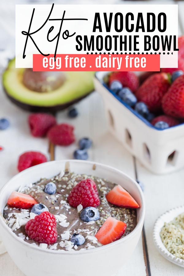 a smoothie bowl next to berries and an avocado