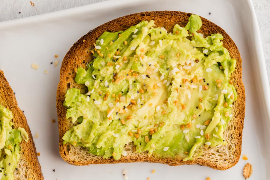 crunchy piece of keto toast topped with avocado spread and topped with seasoning