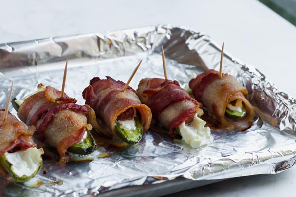 low carb bacon wrapped jalapeno poppers uncooked on a baking tray