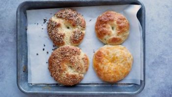 four bagels on a baking tray