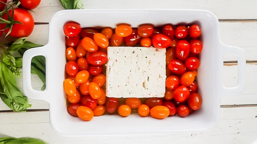 a block of feta nestled in cherry tomatoes