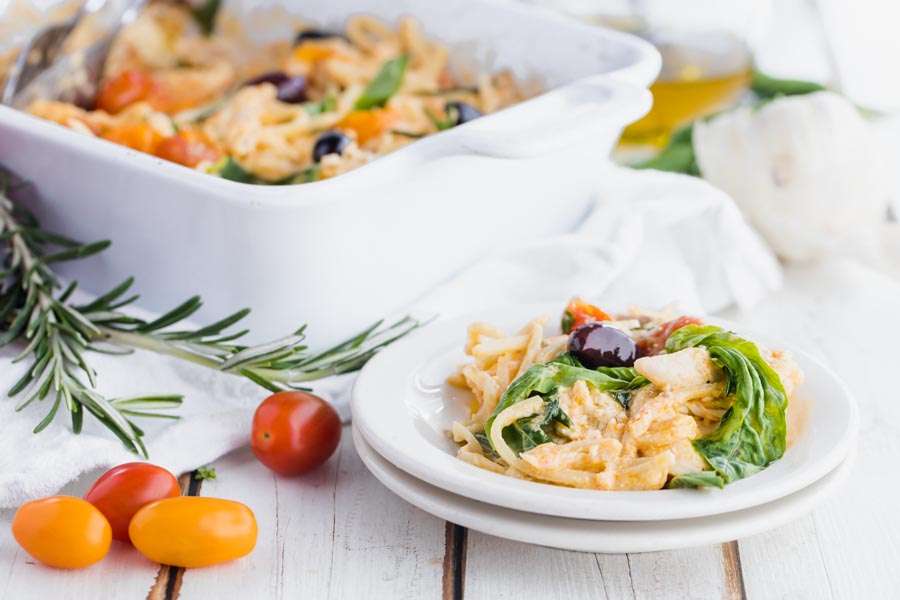 a plate of pasta in front of a casserole dish