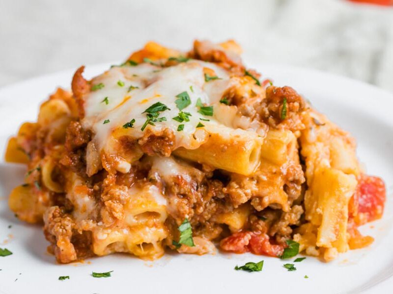 Baked ziti pasta with ground beef and cheese on a plate.