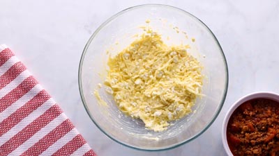 A bowl with cheese and egg mixed together.