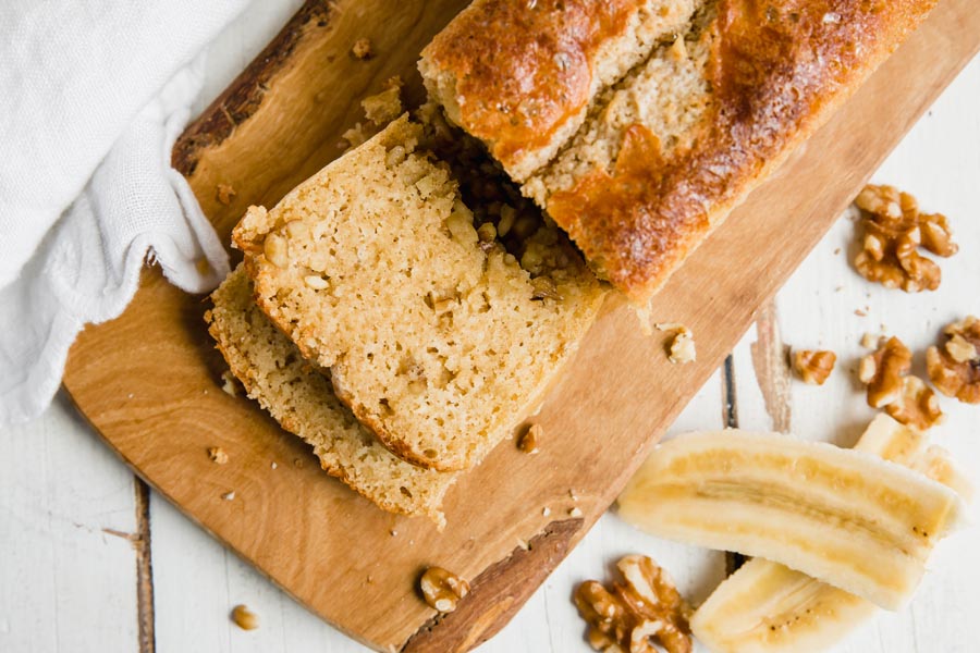 overhead view of a loaf of keto banana walnut bread with nuts scattered around