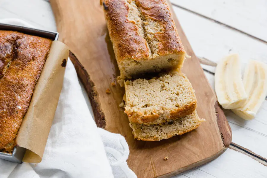 no banana banana nut bread in a loaf pan and on a cutting board