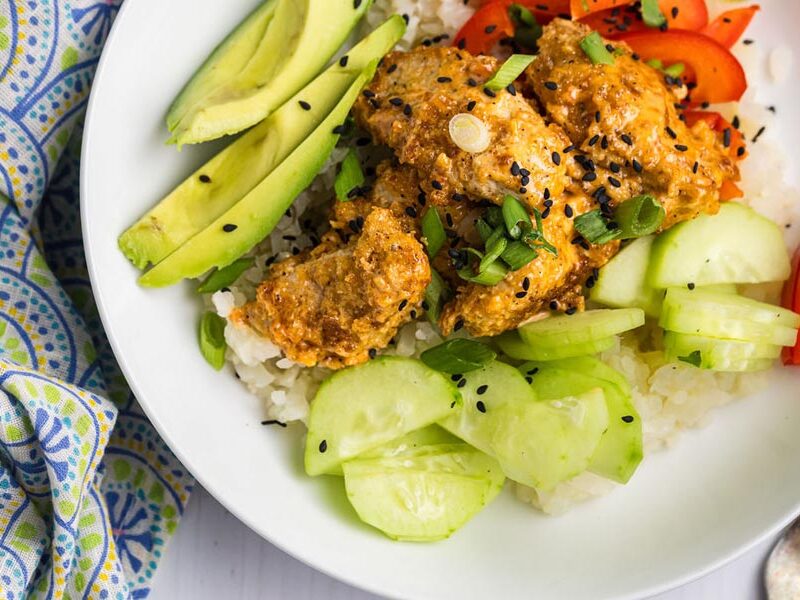 Bang bang chicken bowl with rice, cucumber, avocado and red pepper.
