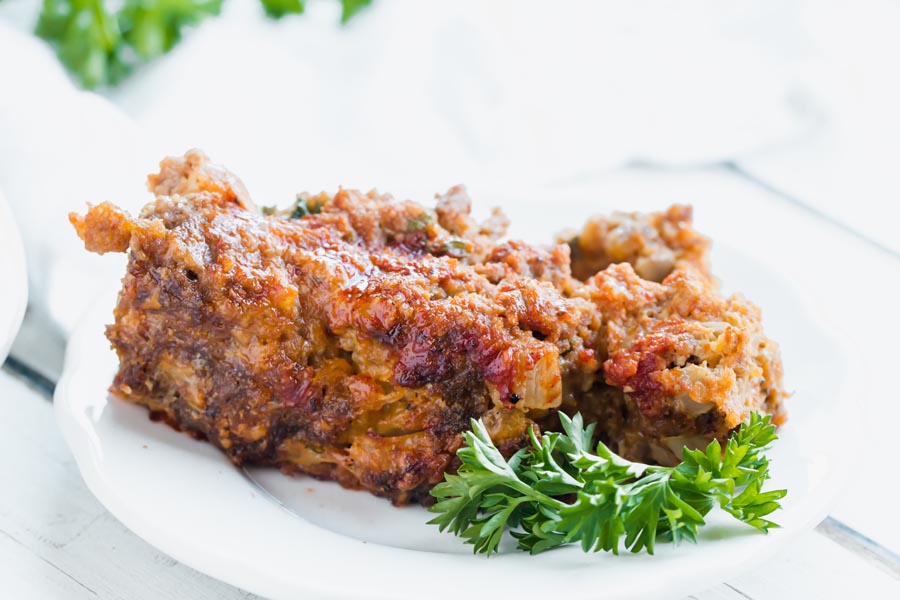 a plate with a slice of low carb bbq cheeseburger meatloaf on it