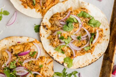 three tostadas layered and staggered on top of each other and topped with onions