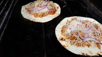 two tostadas cooking on a griddle