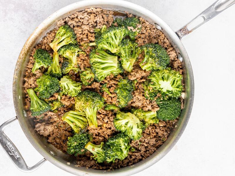 a skillet with beef and broccoli inside