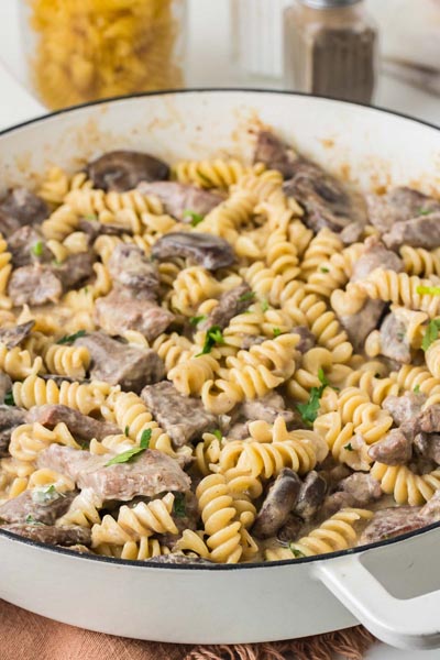 Creamy keto beef stroganoff with tender steak, mushrooms, and low carb rotini pasta served straight from a skillet.