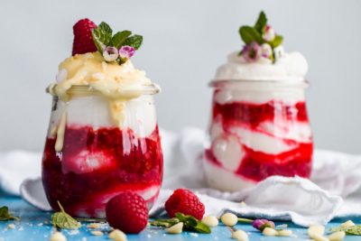 keto raspberry fool with melted white chocolate dripping off the whipped cream