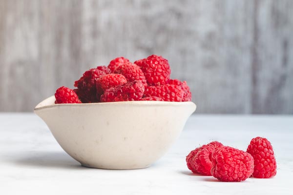 fresh ripe red raspberries in a bowl