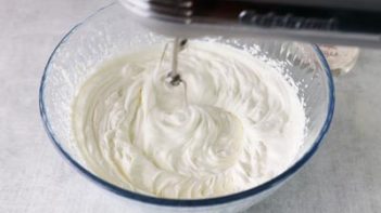 whipping up homemade whipped cream in a bowl with a mixer