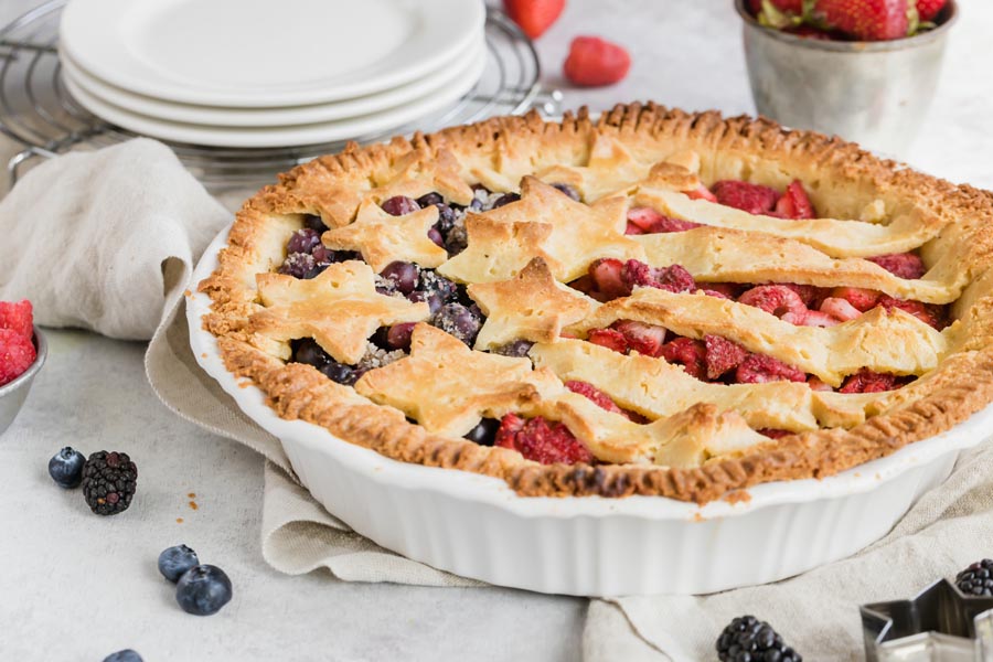 a patriotic pie decorated with berries and stars and stripes crust
