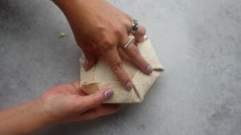 Folding the edges of a crunchwrap.