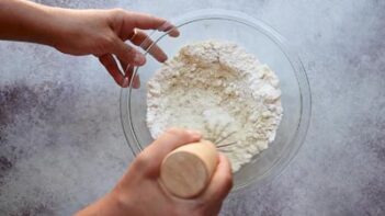 Dry ingredients for the keto white cake being whisked together in a glass bowl.