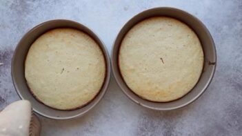Two golden and fluffy keto white cake layers freshly baked and still in the pans.
