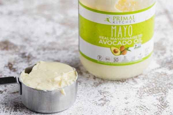 primal kitchen brand avocado mayo next to mayo in a measure cup