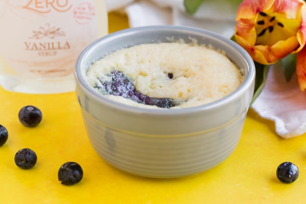 a ramekin with blueberry shortcake in it and berries nearby