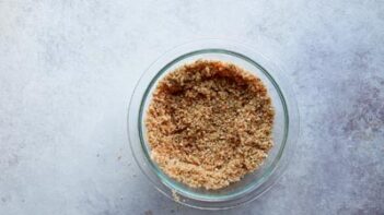 A glass bowl filled with a bread crumb mixture.